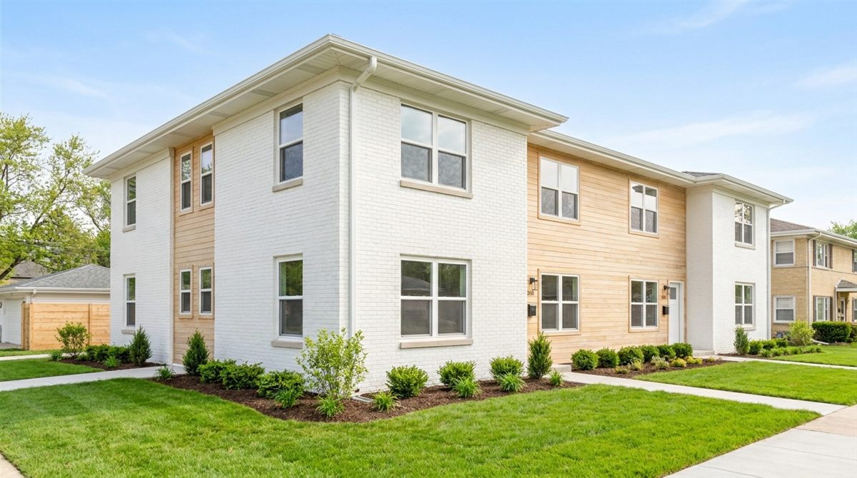 Attractive multi-unit rental property with fresh landscaping in bright daylight representing a like-kind replacement acquisition