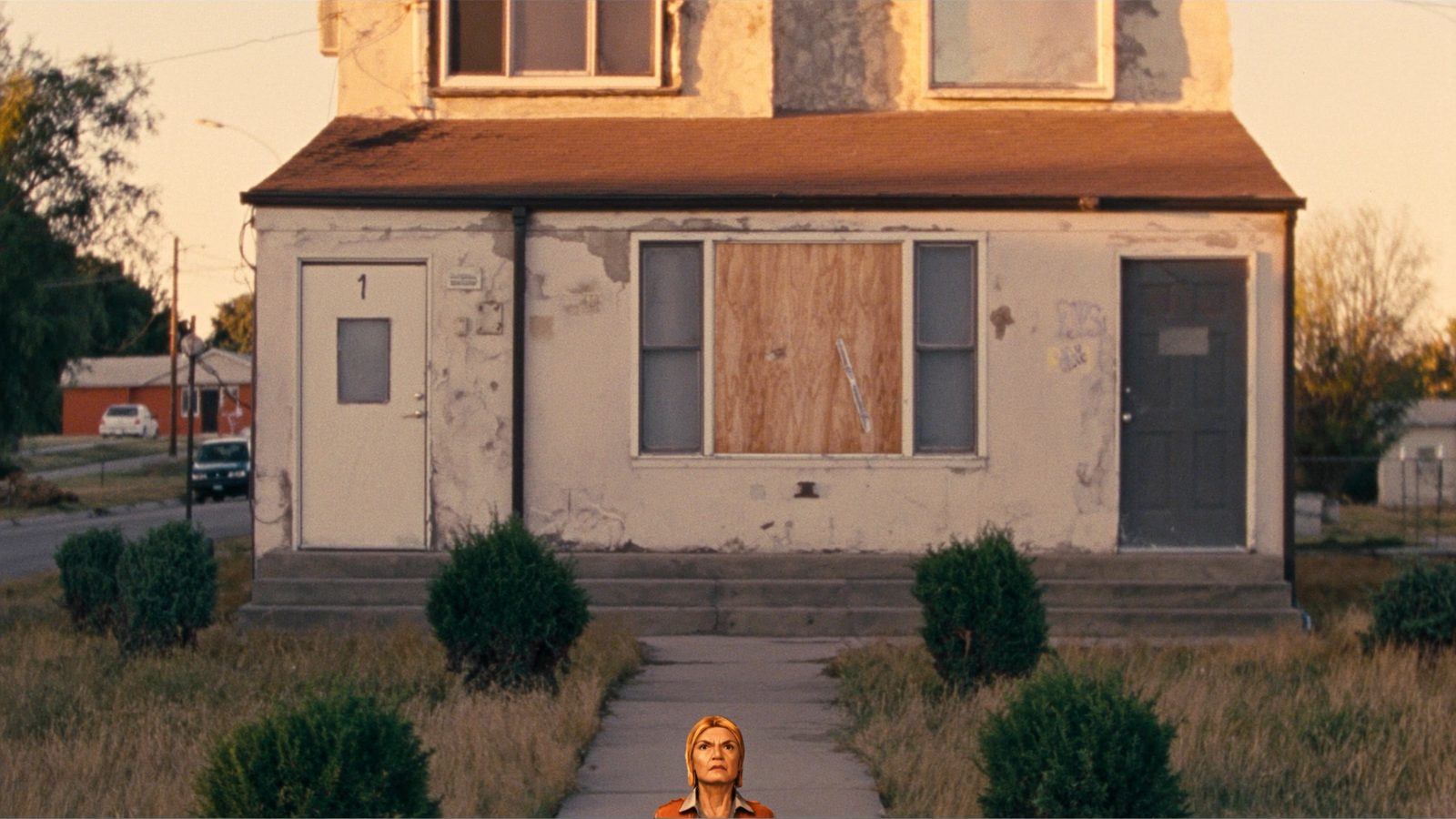 Distressed brick duplex in Denver metro with worn exterior and overgrown yard awaiting investor renovation