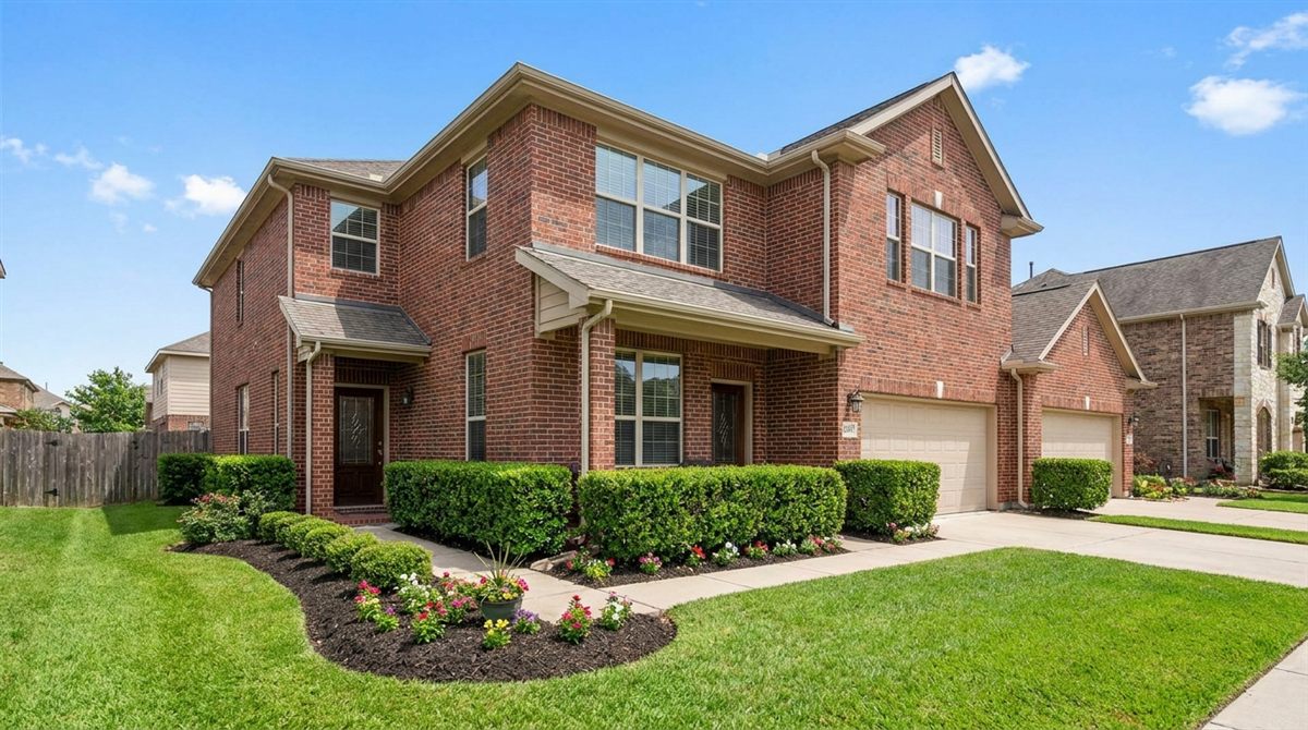 Attractive brick rental duplex with fresh landscaping and blue sky representing a small multifamily investment property in 2026
