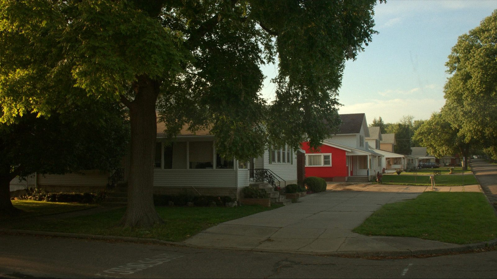 Tree-lined Parma, Ohio street with mid-century single-family homes typical of the suburb's investor housing stock